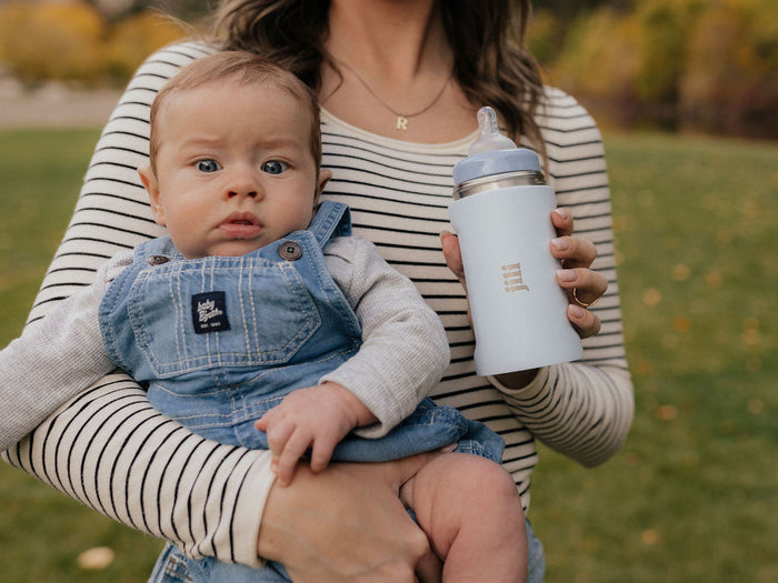 Mom holding her baby outdoors with the Jili Bottle