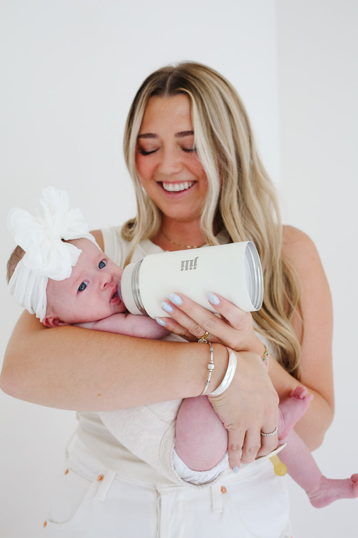 Mom smiling while feeding her baby with the Jili Bottle